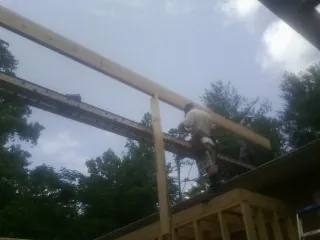 Carpenter setting a ridge beam over a new addition frame — Ice Dam Removal by Roofing Brothers in Shady Valley