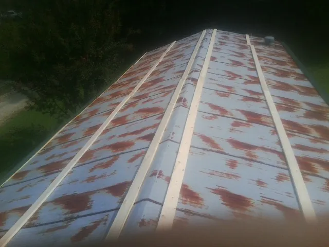 Rusted metal roof panels with new wood purlins before replacement — Storm Damage Roof Repair in Shady Valley by Roofing Brothers